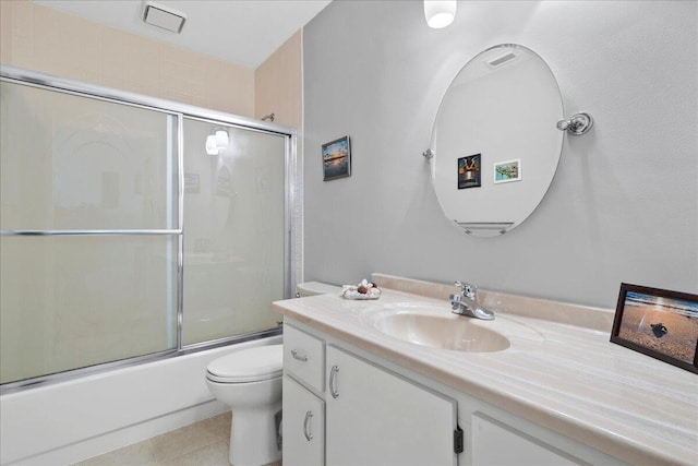 full bathroom featuring shower / bath combination with glass door, tile flooring, vanity, and toilet