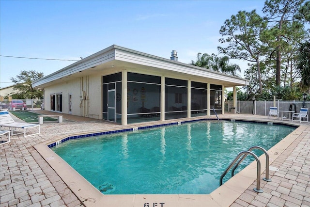 view of swimming pool with a patio and a sunroom