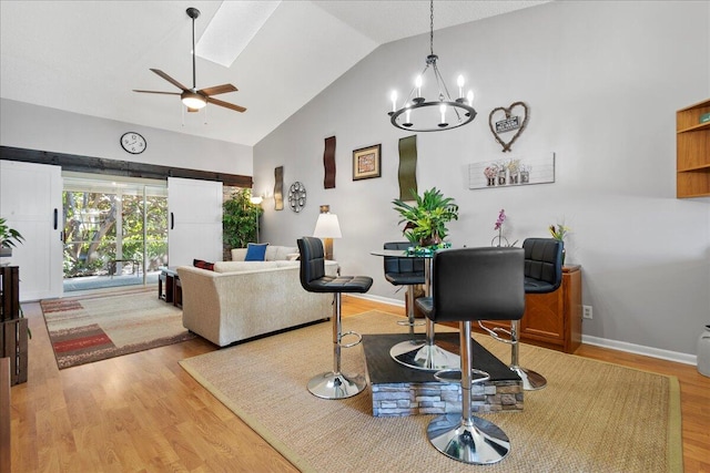 interior space with high vaulted ceiling, ceiling fan with notable chandelier, and hardwood / wood-style floors