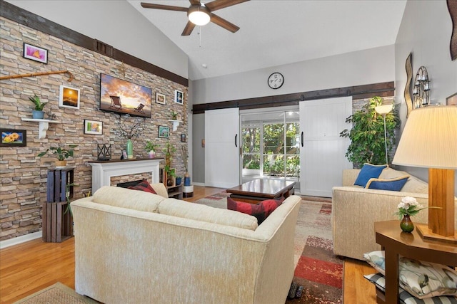 living room with ceiling fan, hardwood / wood-style floors, and lofted ceiling