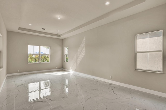 unfurnished room featuring a tray ceiling