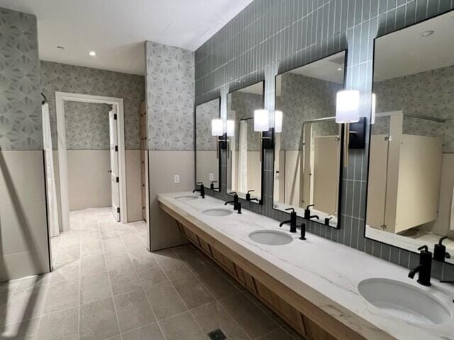 bathroom with vanity, a shower with door, and tile walls