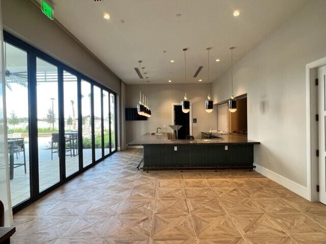 kitchen featuring pendant lighting, a kitchen breakfast bar, kitchen peninsula, and light parquet floors