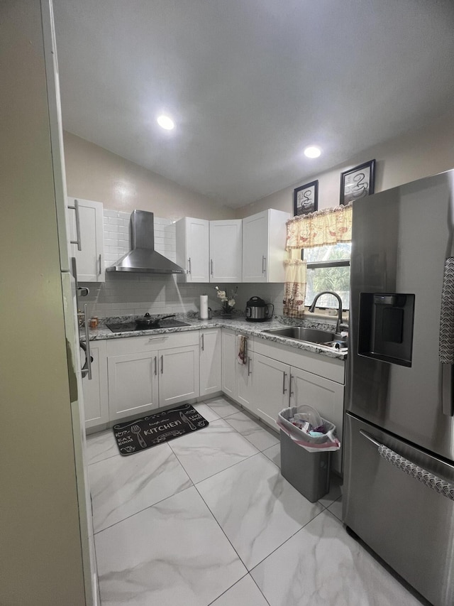 kitchen featuring wall chimney exhaust hood, stainless steel refrigerator with ice dispenser, white cabinetry, and light tile floors