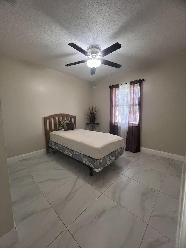 unfurnished bedroom featuring a textured ceiling, ceiling fan, and light tile floors