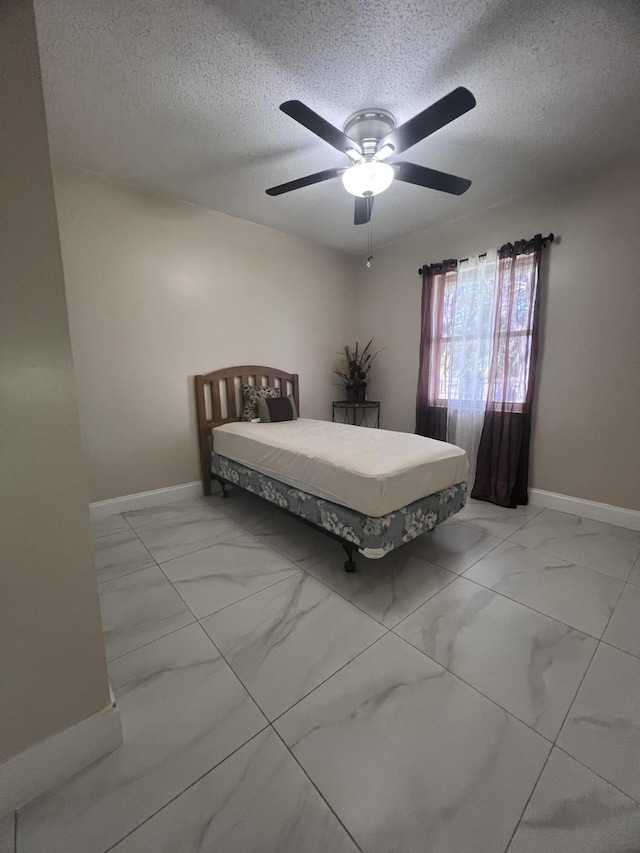 unfurnished bedroom with light tile floors, ceiling fan, and a textured ceiling