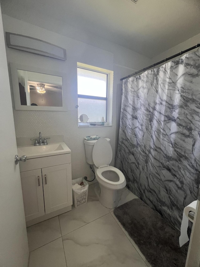 bathroom featuring toilet, tile flooring, and vanity