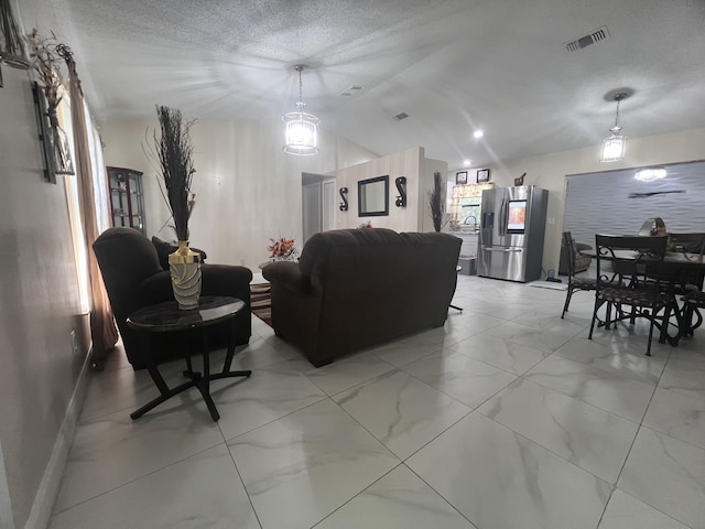 living room with a textured ceiling, light tile floors, and lofted ceiling