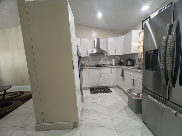 kitchen featuring stainless steel fridge with ice dispenser, wall chimney exhaust hood, tasteful backsplash, and light tile floors