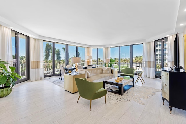 living room featuring plenty of natural light, expansive windows, and light wood-type flooring