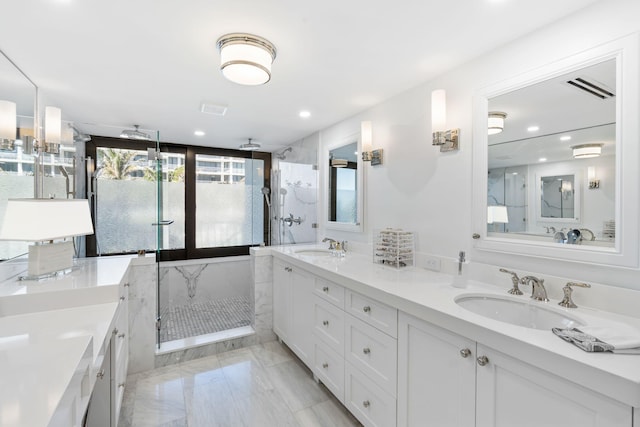 bathroom with tile flooring, large vanity, walk in shower, and dual sinks