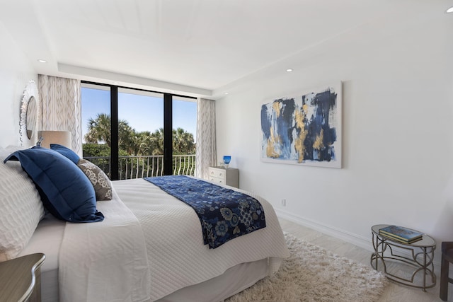 bedroom with access to exterior and light hardwood / wood-style flooring