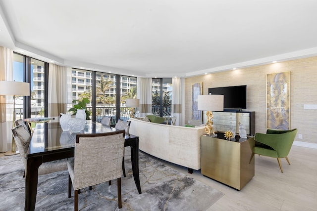 dining room with plenty of natural light, light hardwood / wood-style floors, and a wall of windows