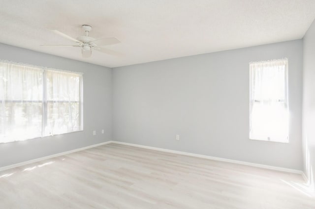 empty room with ceiling fan, light hardwood / wood-style flooring, and a wealth of natural light