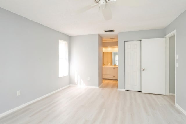 unfurnished bedroom featuring ensuite bath, a closet, ceiling fan, and light hardwood / wood-style flooring