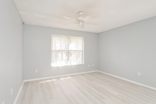 spare room with ceiling fan and light wood-type flooring