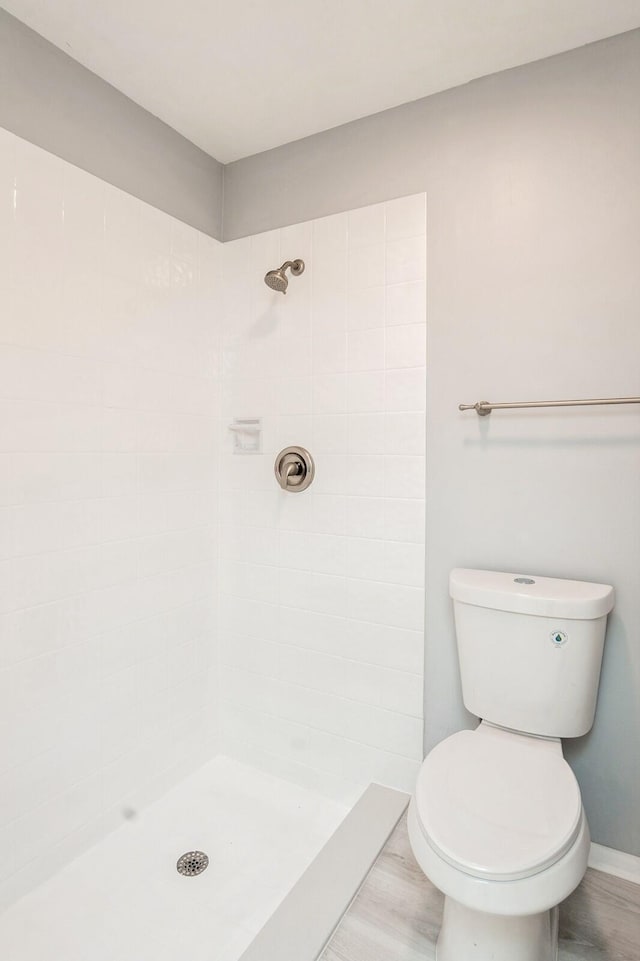 bathroom with toilet and a tile shower