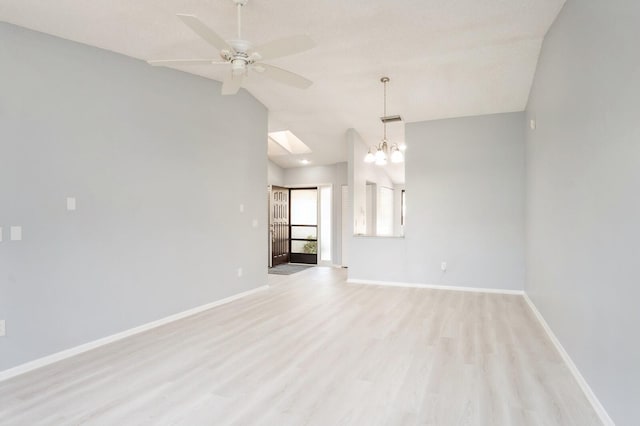 unfurnished room with ceiling fan with notable chandelier, vaulted ceiling, and light wood-type flooring