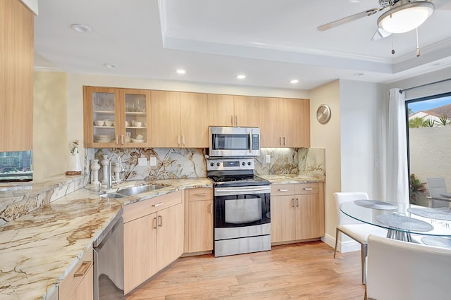 kitchen featuring appliances with stainless steel finishes, sink, light brown cabinetry, and decorative backsplash