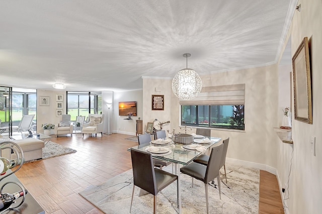 dining room featuring ornamental molding, a chandelier, and light wood-type flooring