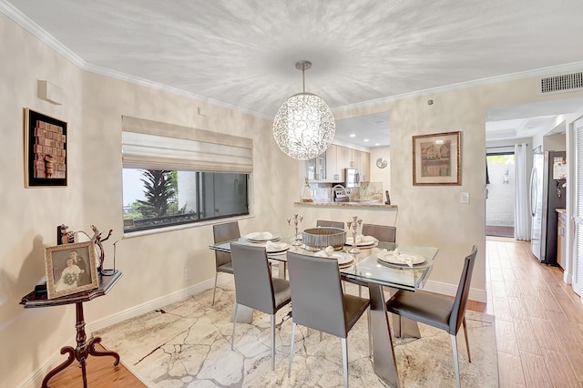 dining space featuring light hardwood / wood-style flooring, crown molding, and a wealth of natural light