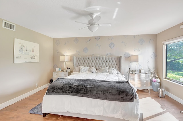 bedroom with ceiling fan, multiple windows, and light wood-type flooring