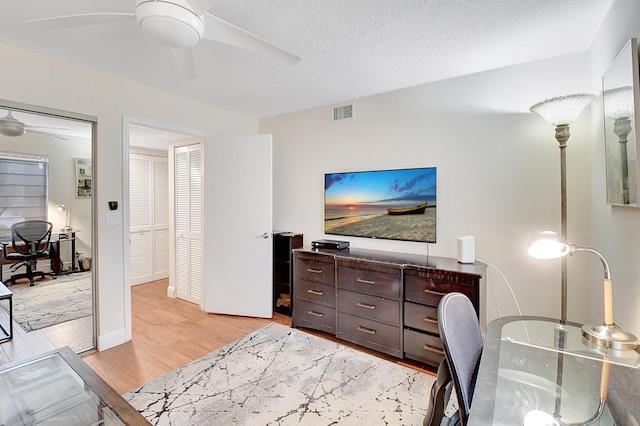 office featuring a textured ceiling, light hardwood / wood-style flooring, and ceiling fan