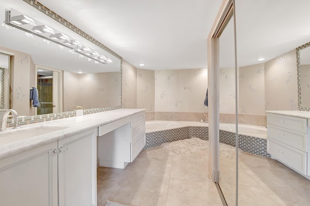 bathroom featuring vanity, tiled tub, and tile patterned floors