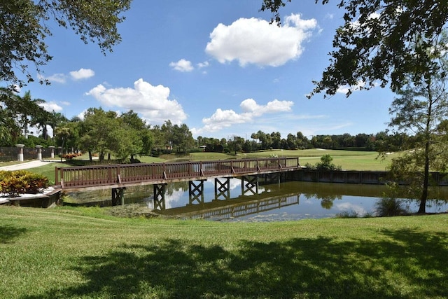 view of dock featuring a water view and a yard