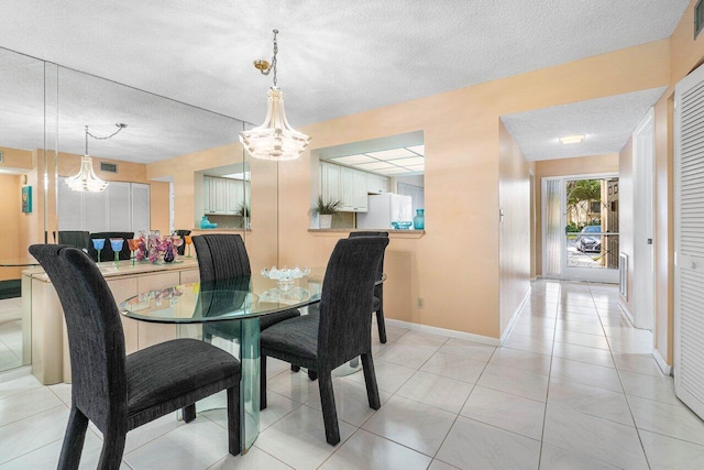 tiled dining space featuring a textured ceiling and an inviting chandelier