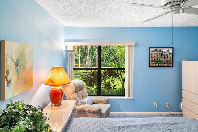 bedroom featuring ceiling fan, a textured ceiling, and multiple windows