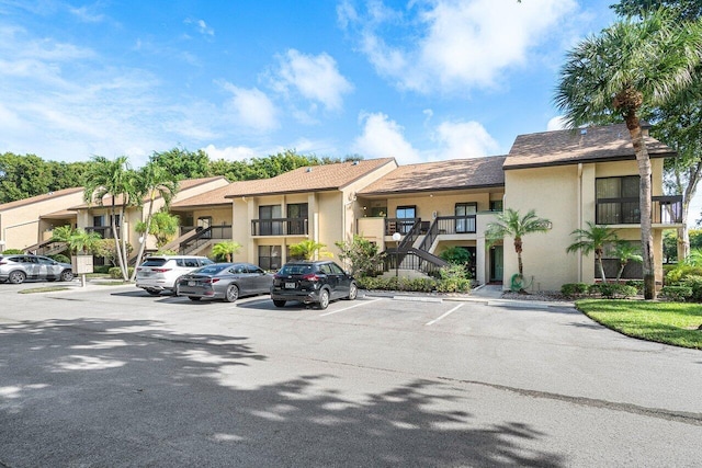 5087 Oak Hill Ln Unit 315, Delray Beach, FL 33484 - view of property featuring uncovered parking and stairs