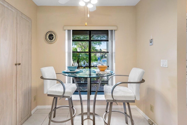 tiled dining space featuring ceiling fan