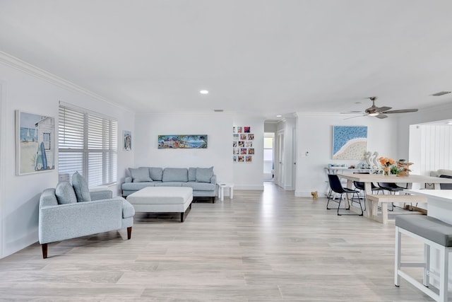 living room with ornamental molding, ceiling fan, and light hardwood / wood-style flooring