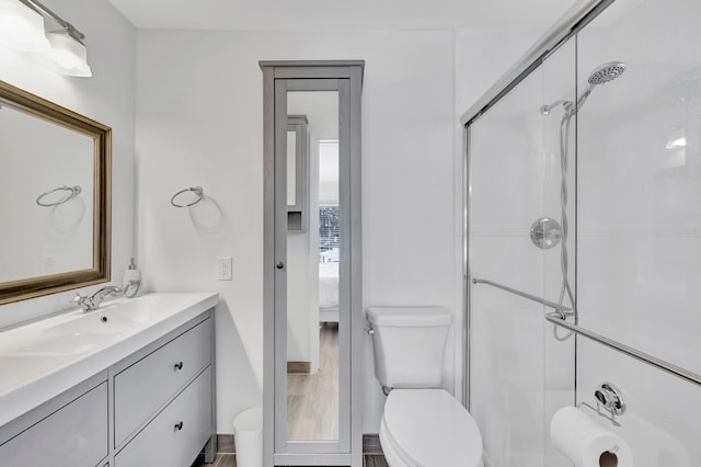 bathroom featuring vanity with extensive cabinet space, a shower with shower door, and toilet