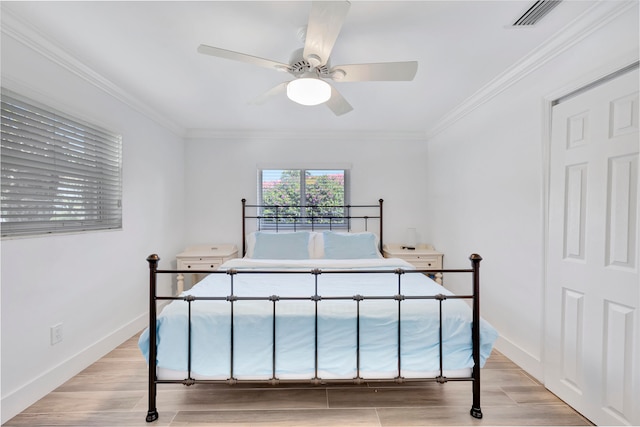 bedroom with crown molding, light wood-type flooring, and ceiling fan