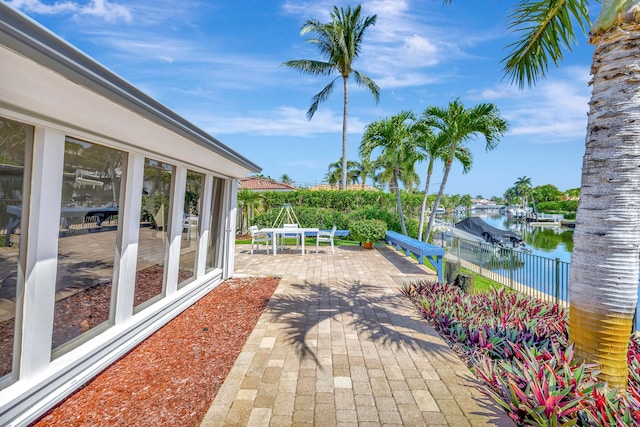 view of patio / terrace with a boat dock and a water view