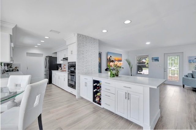 kitchen with white cabinetry, tasteful backsplash, stainless steel refrigerator, and light wood-type flooring