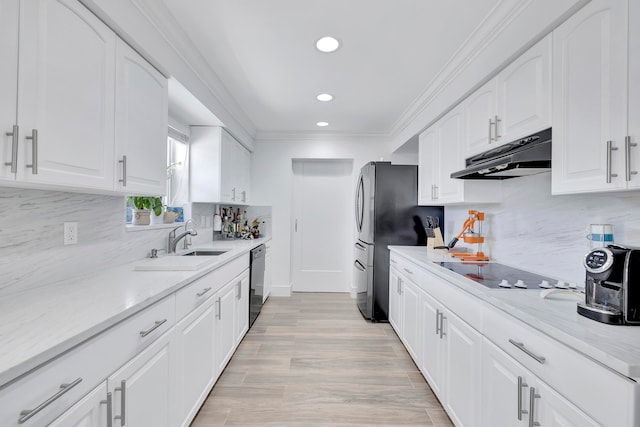 kitchen featuring light hardwood / wood-style floors, stainless steel appliances, white cabinets, backsplash, and sink