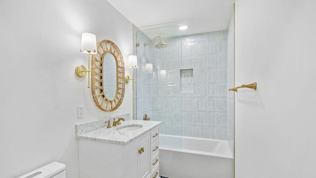 full bathroom featuring toilet, tiled shower / bath combo, and vanity