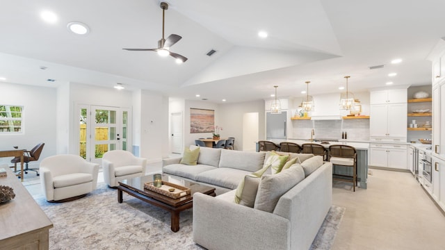 living room featuring high vaulted ceiling and ceiling fan with notable chandelier