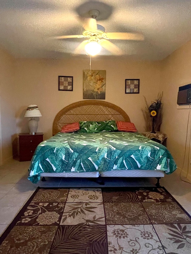 bedroom featuring tile flooring, ceiling fan, and a textured ceiling