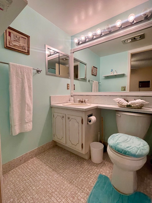 bathroom with toilet, tile flooring, and vanity