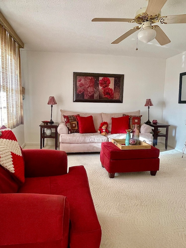 living room featuring a textured ceiling, carpet flooring, and ceiling fan