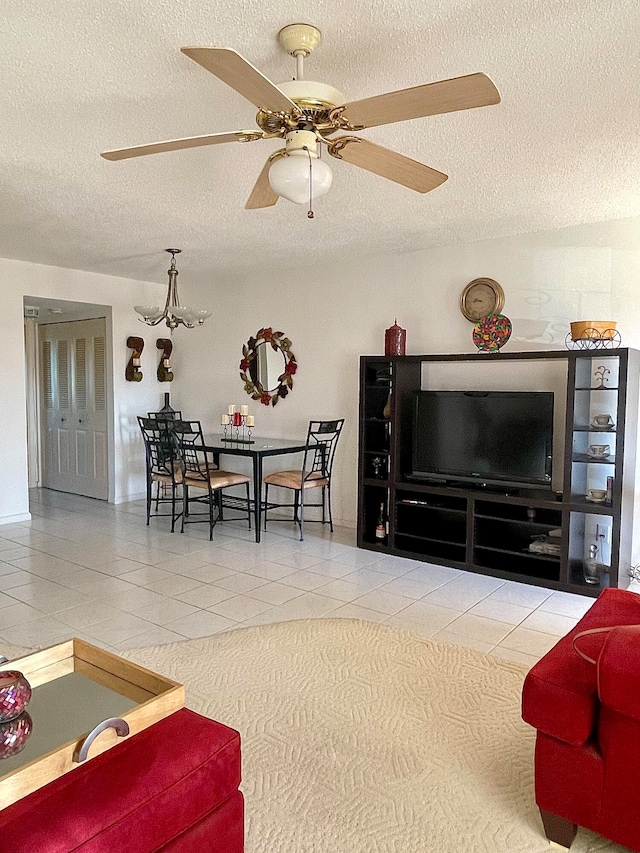 tiled living room with a textured ceiling and ceiling fan