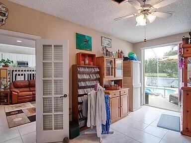 interior space with a textured ceiling and ceiling fan