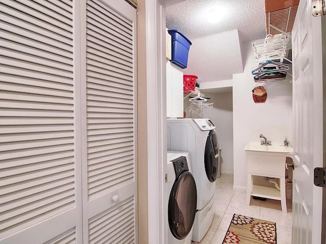 laundry room with light tile floors, a textured ceiling, and independent washer and dryer