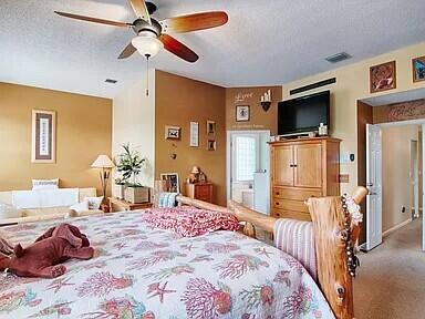 carpeted bedroom with ceiling fan and a textured ceiling