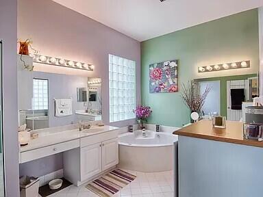 bathroom featuring a bath, large vanity, and tile flooring