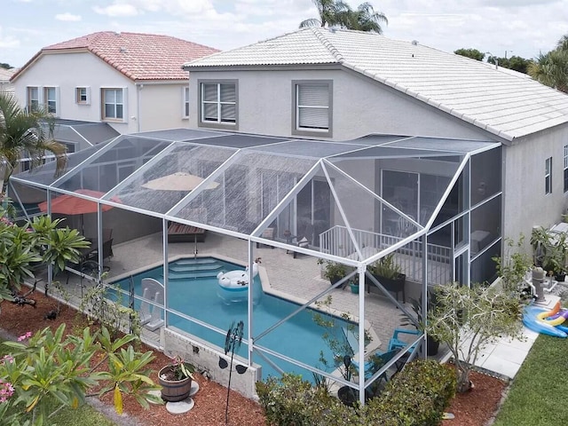 rear view of house featuring glass enclosure